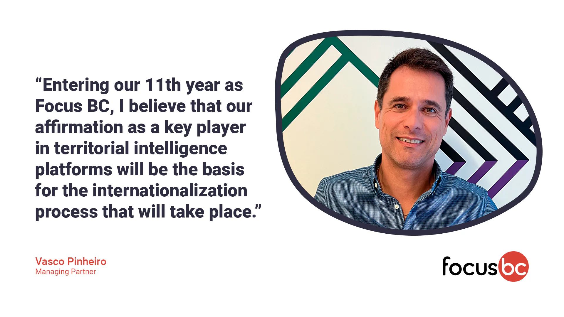 Colleagues gathered around a long dining table in a restaurant, sharing a meal and posing for a group photo.