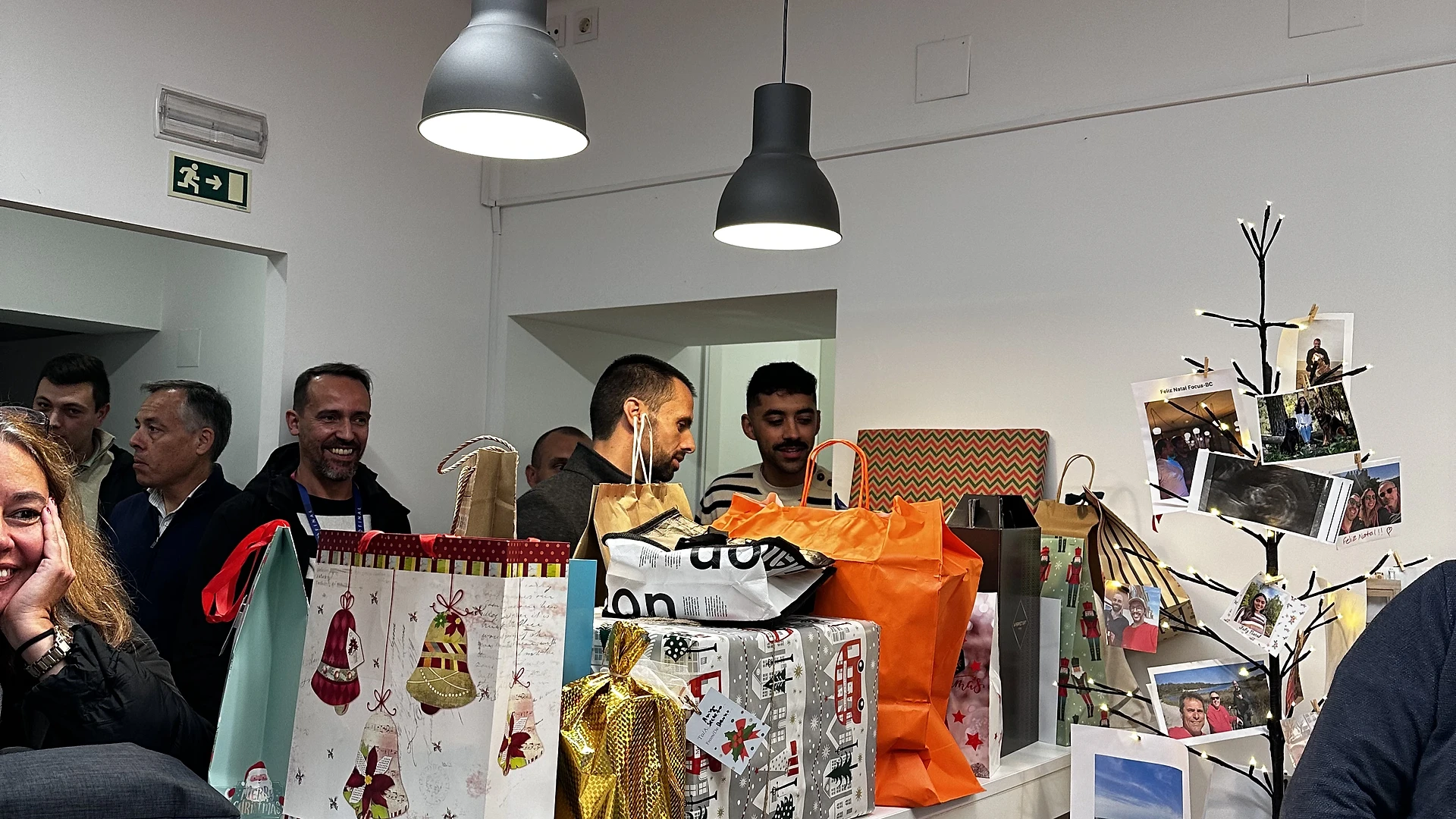 The illuminated Christmas tree decorated with team photos and handwritten holiday notes.
