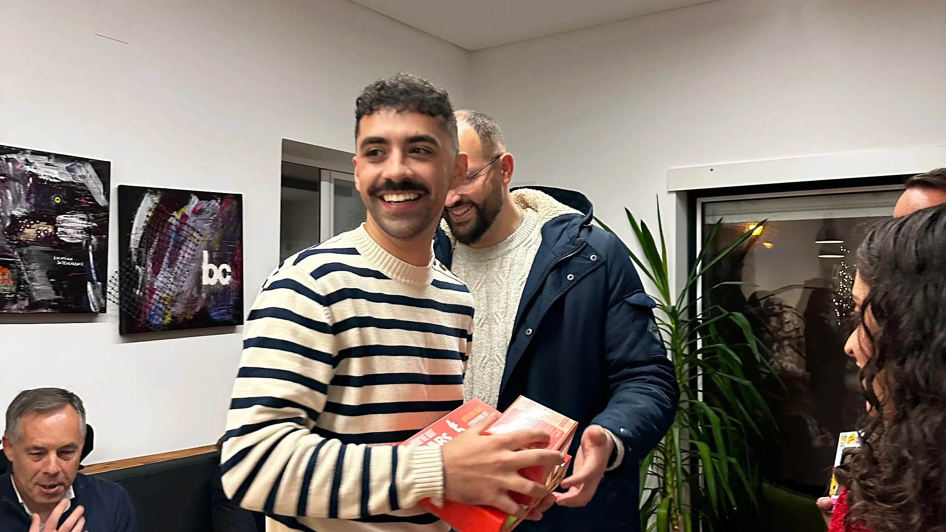 Food donations collected indoors, with grocery bags and supplies placed on tables and the floor at a community food center.