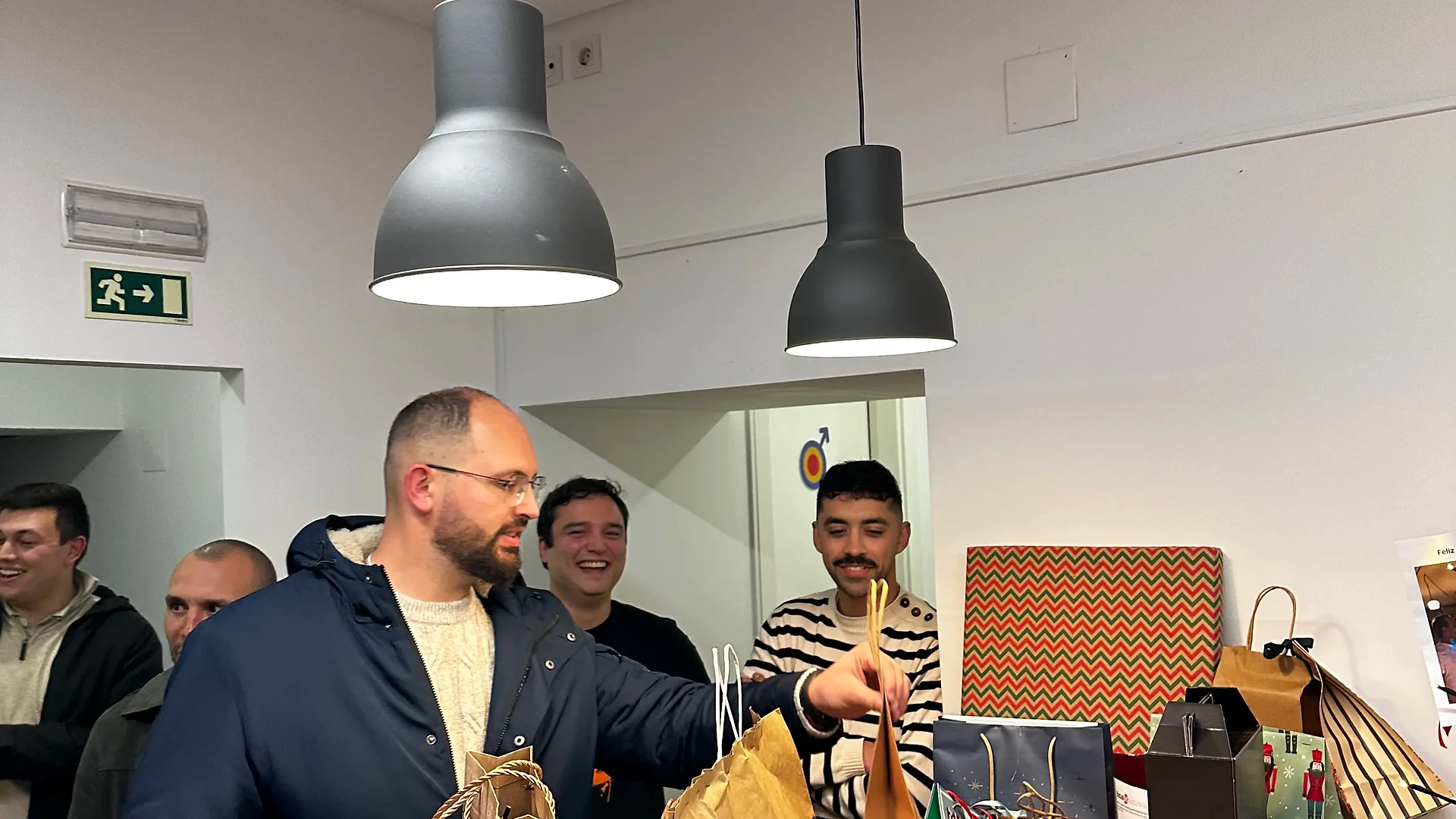 Food donations collected indoors, with grocery bags and supplies placed on tables and the floor at a community food center.