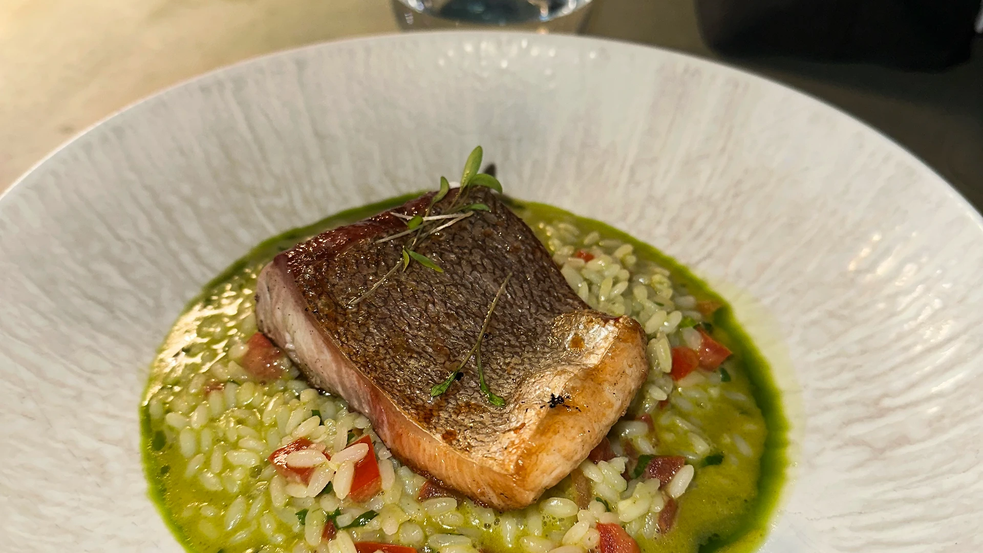 Multiple grocery bags with food supplies placed beside colorful bean bags in an office space, prepared for donation.