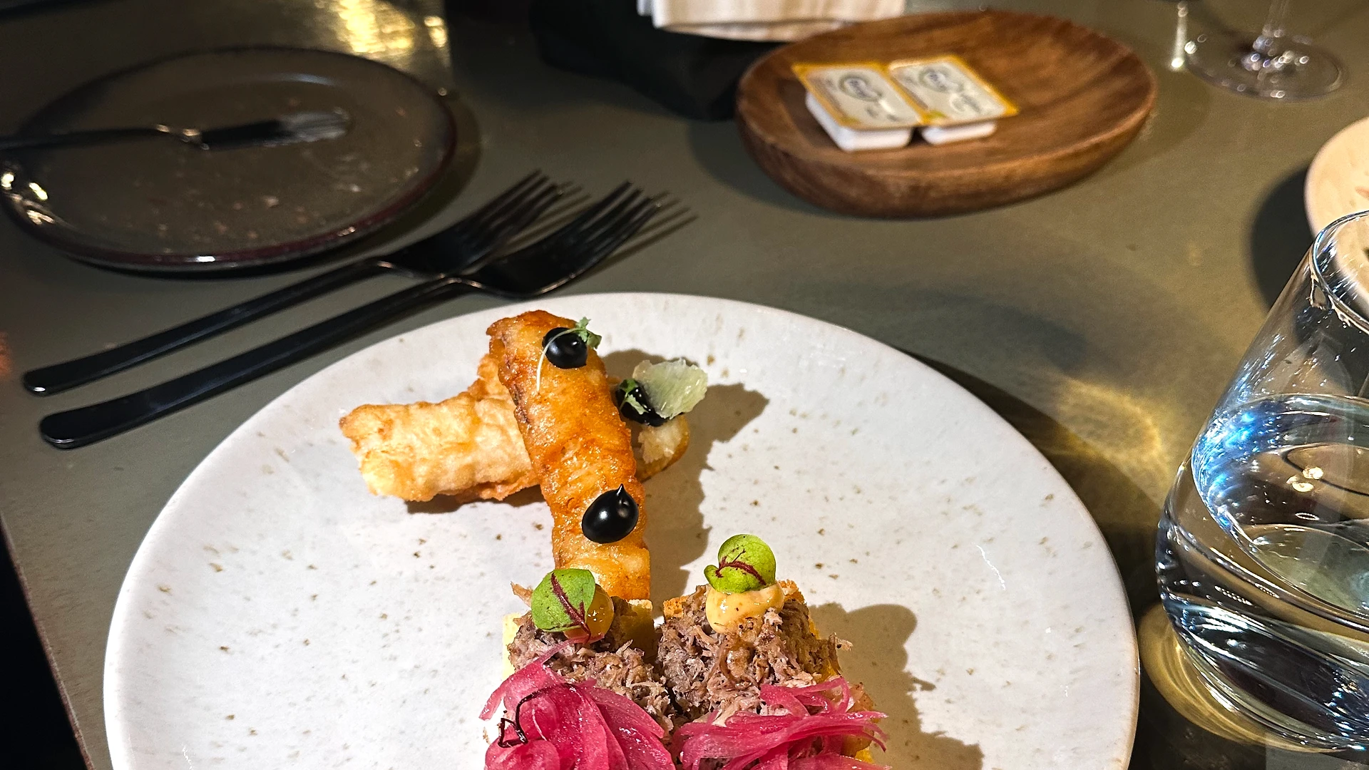 Colleagues gathered around a table filled with wrapped gifts during an office Secret Santa exchange.