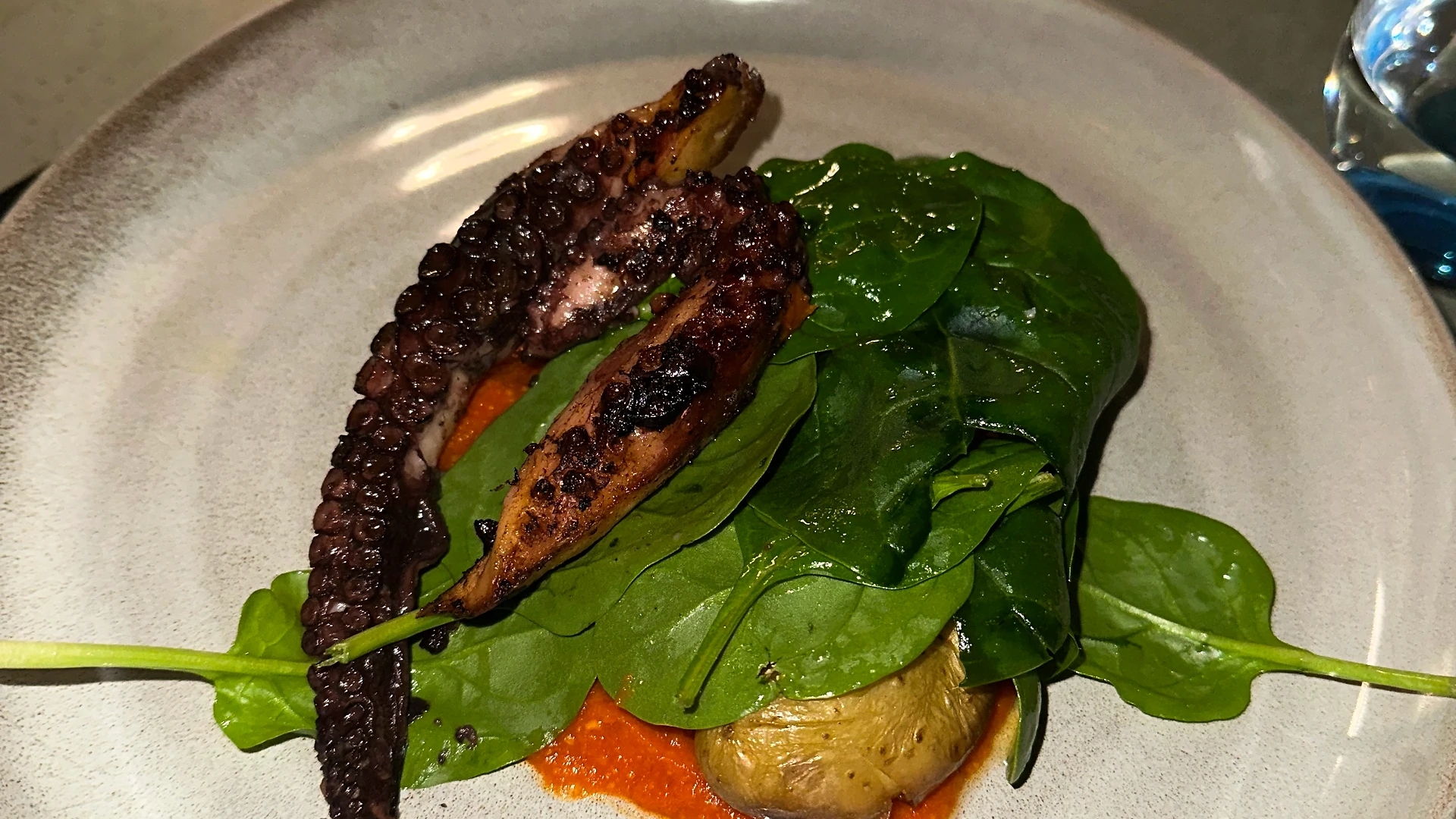 Three team members chatting and smiling, one speaking animatedly while holding a drink.