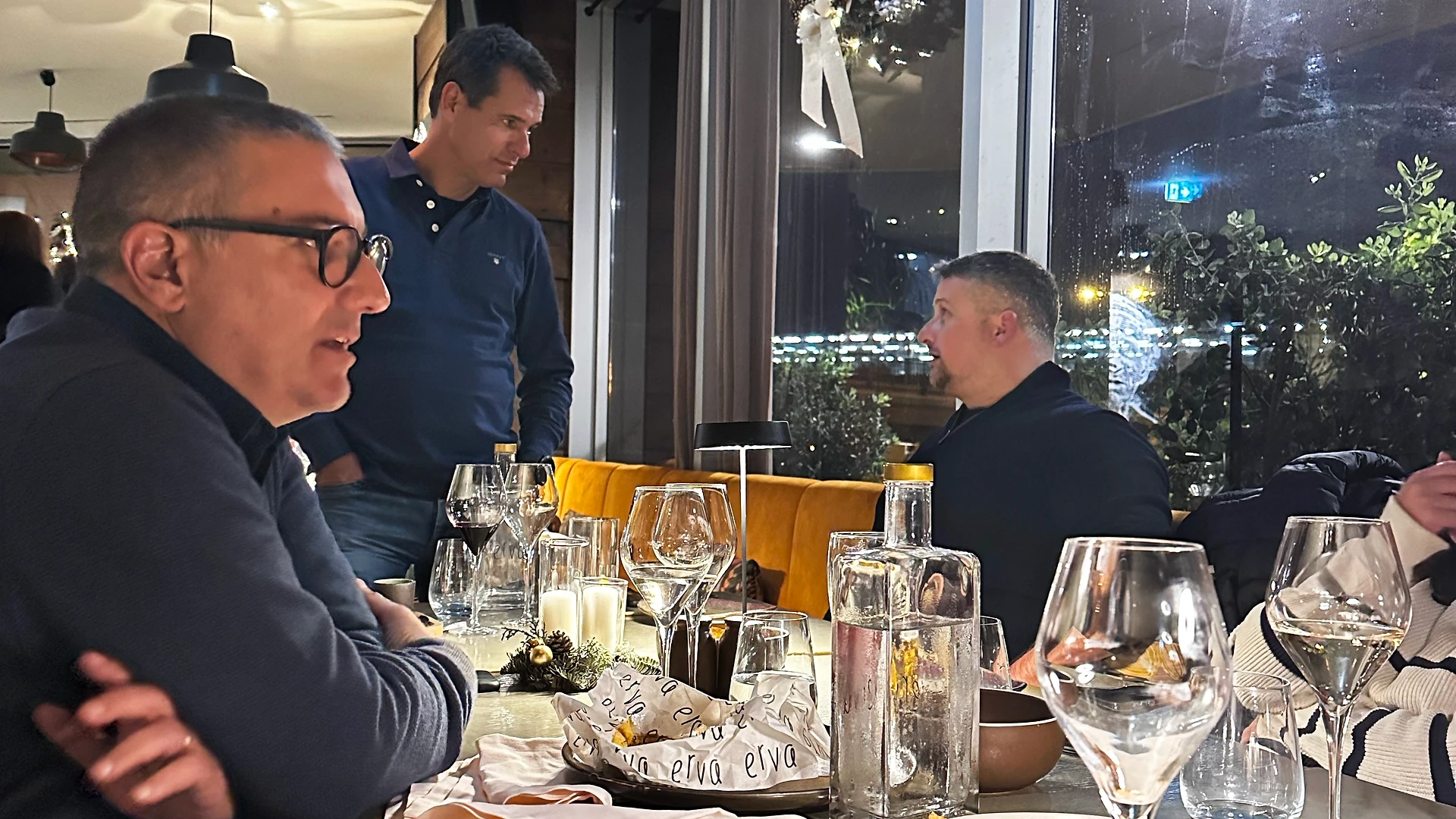 A team member reading from a paper while others stand nearby listening during the gift exchange.