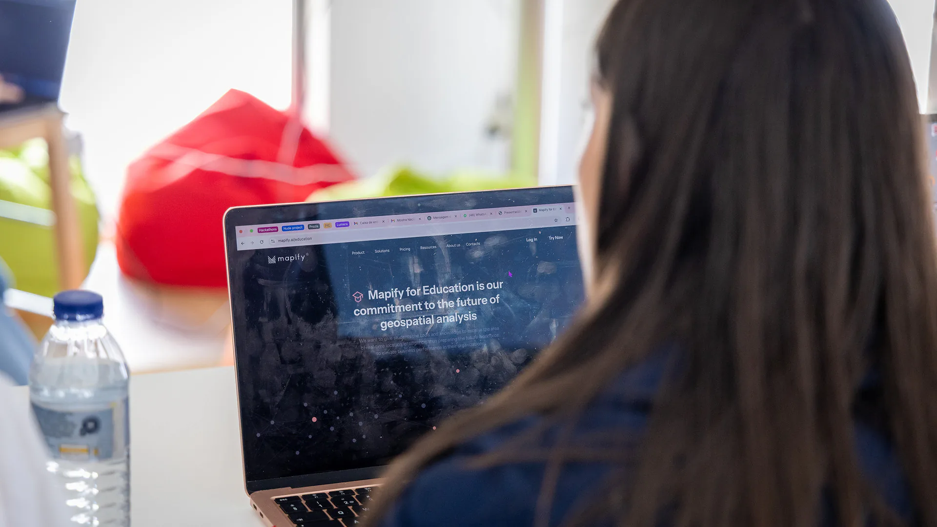Close-up of Nuno Serra, in a mauve polo shirt and glasses (Mario Sobral) engaged in an expressive conversation with a participant. He appears to be explaining something during a one-on-one moment in the workshop.