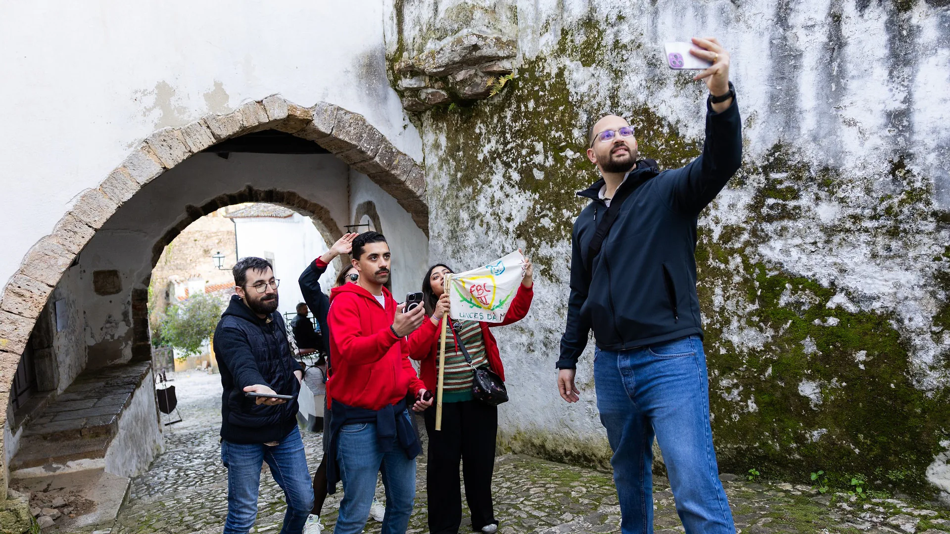 Two men singing together into a microphone, laughing and enjoying the karaoke performance in a restaurant setting.