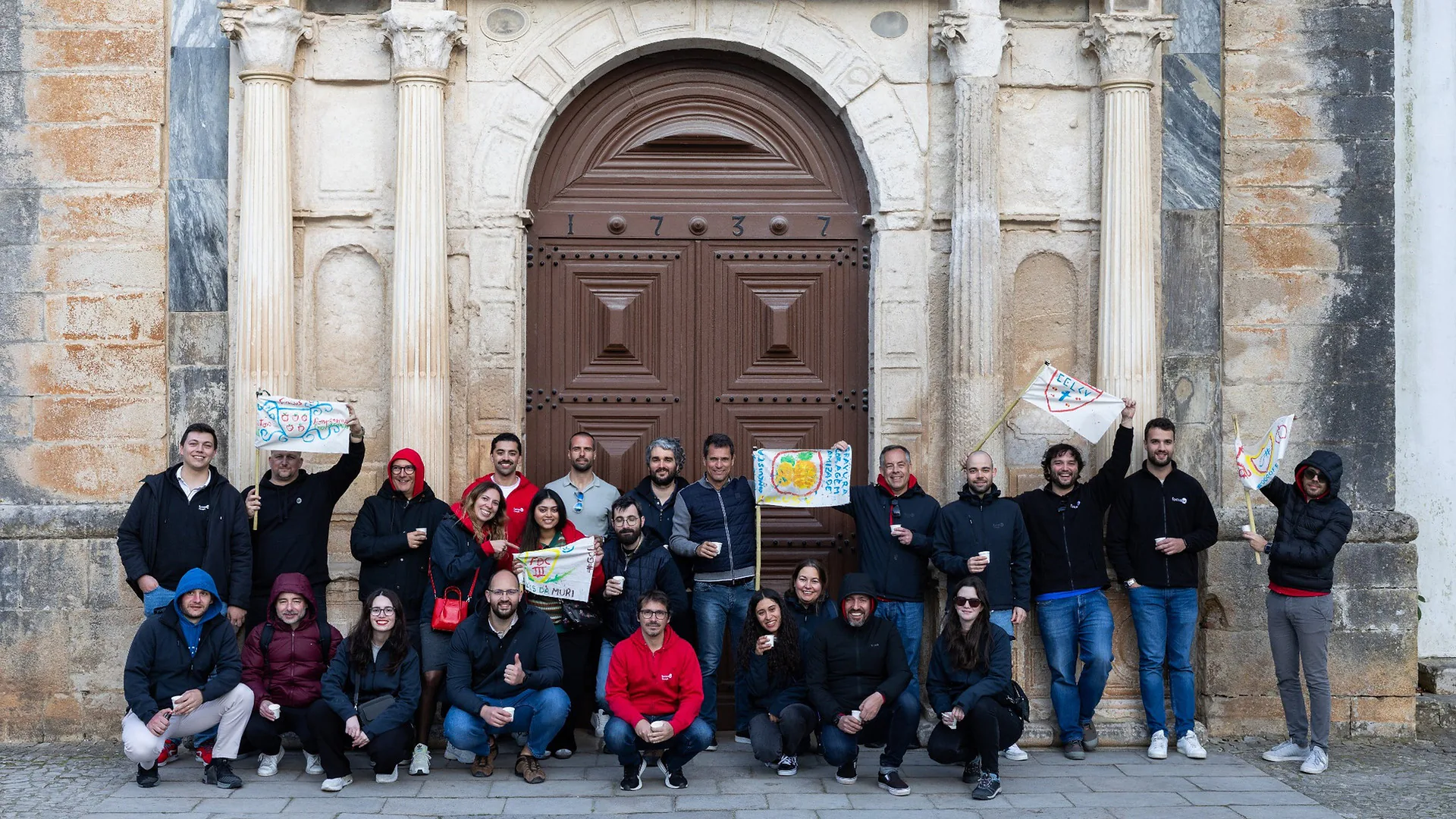 Group of women singing into microphones during karaoke, standing in front of a wall with warm ambient lighting.